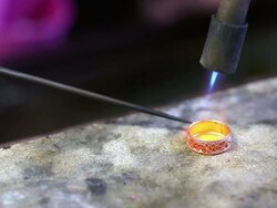 Goldsmith Jeweler use gasoline burner melting and decorating gold Stock Footage