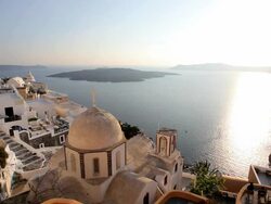 Dome of the local church and the white washed houses of Thira overlooking the Aegean Sea on the Island of Santorini, Greece, Europe Stock Footage