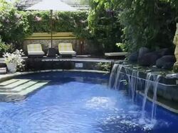 MS View of Hotel swimming pool with little waterfall at Asia / Candi, Dasa Bali, Indonesia Stock Footage
