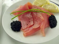 Smoked salmon & caviar rotate on a white plate with lemon & dill Stock Footage