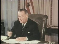 President Lyndon B. Johnson signs documents in the Oval Office of the White House. News Clip