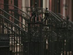Slow zoom out reveal from the gate up front to a wide shot of brownstones from the sidewalk of a new york city street during the day Stock Footage