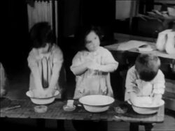 B/W 1934 3 children standing at basins washing themselves at nursery school / WPA project / newsreel Stock Footage