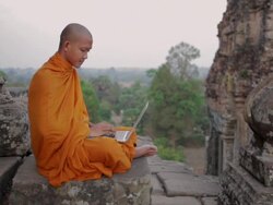 WS, PAN A Buddhist monk uses a laptop computer on top of an ancient temple in Angkor Wat / Siem Reap, Cambodia Stock Footage