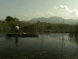 Slow motion man punting across pond, wide angle, Spain (Individual frames may also be used as a still image. Each frame in its raw state is about 6MB or about 12MB as a 16 bit TIFF) Stock Footage