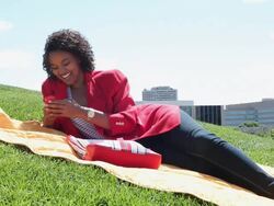 MS Young girl using cellular device outside in park on sunny day while lying on blanket / Minneapolis, Minnesota, United States Stock Footage