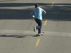 A young man skateboarding in the middle of the street. - Slow Motion Stock Footage