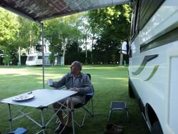 WS mature man sitting reading and drinking tea in front of  camper van/Bungay/Suffolk/UK Stock Footage