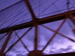 A cabled suspension bridge crosses a river. Stock Footage