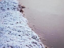 CU Salt sand next to shimmering desert water in evening sunlight / Trona, California, United States Stock Footage