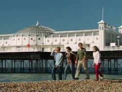 WS, PAN, Family with two children (10-11, 12-13) walking on Brighton beach, Brighton, Sussex, United Kingdom Stock Footage