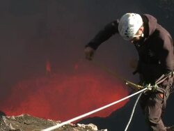 Climber prepares to descend into active volcano and lava lake, Marum Volcano, Ambrym Island, Vanuatu Stock Footage
