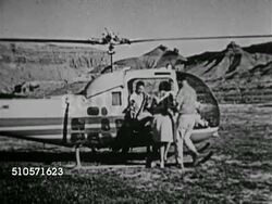 1964: CHEVROLET COMMERCIAL: BEHIND THE SCENES: TU WS ZI Castle Rock. AERIAL: WS Passing Castle Rock w/ new Chevrolet Impala convertible sitting on top of pinnacle w/ Model Shirley Rumsey in car, VS Passing top of cliff & car. Unique, location, unusual Instructional Video