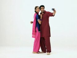 Punjabi couple taking picture of themselves with a digital camera Stock Footage