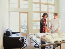 Architects in office with blueprints and design model Stock Footage