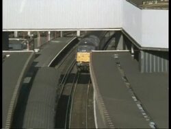 High angle view of train arriving at station, camera zooms out Stock Footage