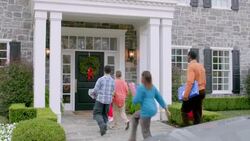 Excited grandfather welcomes family home for the holidays, hugs all around (dolly-shot) Stock Footage