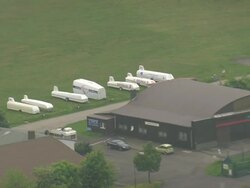 MS AERIAL ZO Shot of vehicles parked on landscape with hotel and hills at Wasserkuppe / Germany Stock Footage