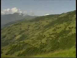 WA green hillside, pan left to grey smoke and ash cloud rising quickly upwards from crater, Mount Tunguragua, Ecuador Stock Footage