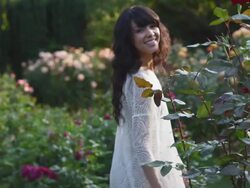 MS TS SLO MO Shot of beautiful brunette walking in rose garden / Portland, Oregon, United States  Stock Footage
