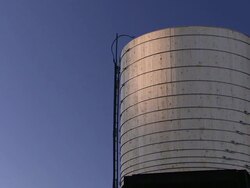 A narrow ladder scales the side of a small water tank in a New York City neighborhood. Stock Footage
