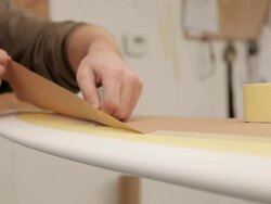 CU Shot of shaper masking up surfboard before glassing / Wadebridge, Cornwall, United Kingdom Stock Footage
