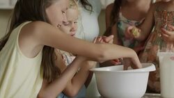 Close up panning shot of mother and daughters baking cookies / Orem, Utah, United States Stock Footage