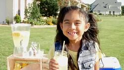 Adorable Asian little girl smiling in front of lemonade stand Stock Footage