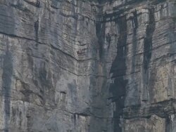 Wing suit flier jumps from cliff and soars above valley below Stock Footage