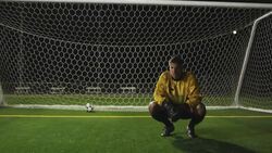 A crouching goaltender buries his face in his hands after missing a shot. Stock Footage