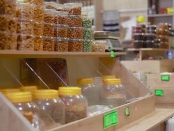 Woman buys jar of pistachios in grocery Stock Footage