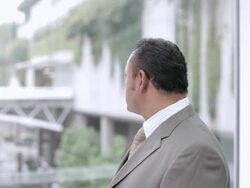  PAN Businessman looking out window and turning head to smile / Seattle, Washington, United States Stock Footage