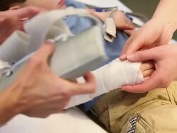 Female doctor wrapping up boy's arm Stock Footage