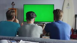 Guys sitting on couch watching tv and switching Stock Footage