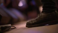 Guitar player taps boots with rhythm on stage at crowded rock concert Stock Footage
