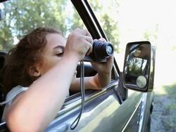 Girl taking pictures from window of automobile Stock Footage