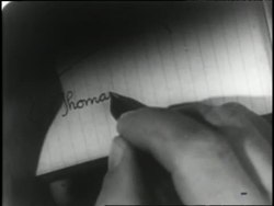 An actor reenacts Thomas Edison signing his name with a quill pen. News Clip