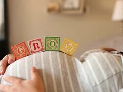 A pregnant women using blocks to spell the word GIRL on her stomach. Stock Footage
