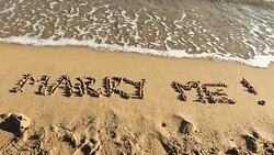 MARRY ME! written in sand Stock Footage