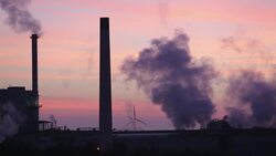 Sunset over the Iggesund paper board manufacturer in Workington, Cumbria, UK, at sunset, with wind turbines. The plant is powered by a biofuel power station, on site. Stock Footage