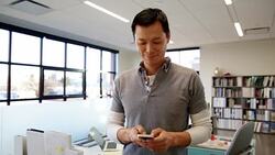 Businessman texting on cell phone in office Stock Footage