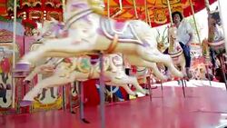 People riding carousel at amusement park Stock Footage