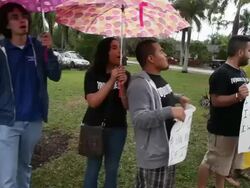 Mid tracking shot of protesters chanting and holding banners, close up to protester Immigration Activists Protest Outside Of Marco Rubio Fundraiser at Biltmore Hotel on April 05, 2013 in Miami, Florida (Footage by Getty Images)Immigration Activists Protest Stock Footage