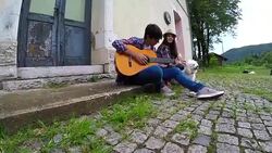 Young couple in love playing acoustic guitar in the park Stock Footage
