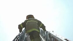 Firefighter climbs truck ladder, Detroit, day Stock Footage