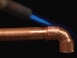 Soldering and sweating copper elbow coupling tubing with propane torch Stock Footage