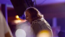 Rock musician sings and plays guitar with band on stage at music festival Stock Footage