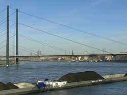 WS View of Dusseldorf city with cargo ship in Rhine river and Oberkassel Bridge / Cologne, North Rhine Westphalia, Germany Stock Footage