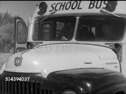 1952: LABETTE COUNTY SCHOOL BUS:  VS School bus driving, pulling to a stop, 'stop' sign on side of bus, young boys w/ books running to & boarding bus, bus driving away on rural road, buses arriving, students entering Labette County H.S. Kansas, KS Instructional Video