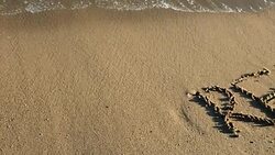 RELAX written on sandy beach Stock Footage